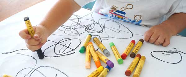 Small Child Hands Drawing with Crayons